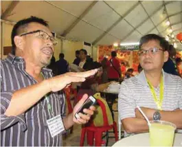  ??  ?? Arlene Valera (left) addressing a group that included Ricky Sun at the Agrilink trade expo.
