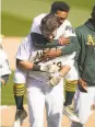  ?? Jeff Chiu / Associated Press ?? Tony Kemp hops on Mitch Moreland’s back after an A’s win April 7.