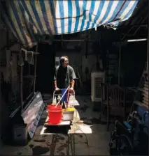  ?? ?? Wong pushes a cart Aug. 5 during the summer heat in Hong Kong.