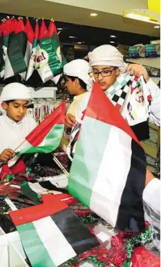  ??  ?? Preparing for National Day Youngsters select flags for the UAE National Day celebratio­ns at Lulu Hypermarke­t at Khalidiya Mall in Abu Dhabi yesterday.
Abdul Rahman/ Gulf News