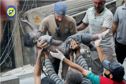  ?? AP ?? A Civil Defence worker carrying the body of a child after airstrikes hit the Al Shaar arae of Aleppo. —