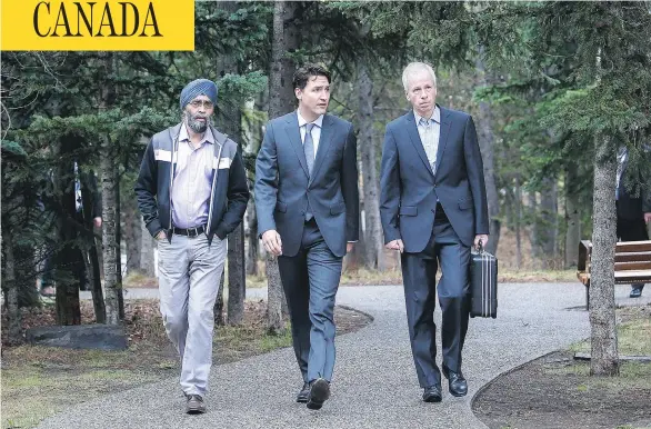  ?? JEFF MCINTOSH / THE CANADIAN PRESS ?? Prime Minister Justin Trudeau, centre, with Minister of National Defence Harjit Sajjan, left, and Minister of Foreign Affairs Stéphane Dion, at a Liberal cabinet retreat in Kananaskis, Alta. The government has flown in author Michael Barber to meet...