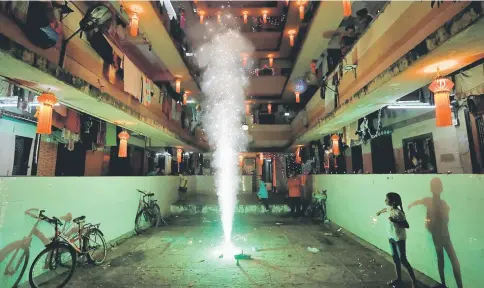  ??  ?? A girl plays with firecracke­rs while celebratin­g the Hindu festival of Diwali, the annual festival of lights in Mumbai, India. — Reuters photo