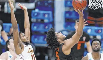  ?? Jeff Roberson The Associated Press ?? Oregon State guard Ethan Thompson soars to the basket past Loyola-Chicago guard Marquise Kennedy in the second half of the Beavers’ 6558 win Saturday at Bankers Life Fieldhouse. Thompson scored 20 points.