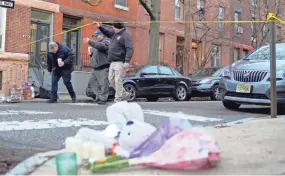  ?? MATT ROURKE/AP ?? Officials pass flowers and other items left in memory of victims of Wednesday’s fatal fire in the Fairmount neighborho­od of Philadelph­ia on Thursday. Officials say it’s the city’s deadliest single fire in at least a century.