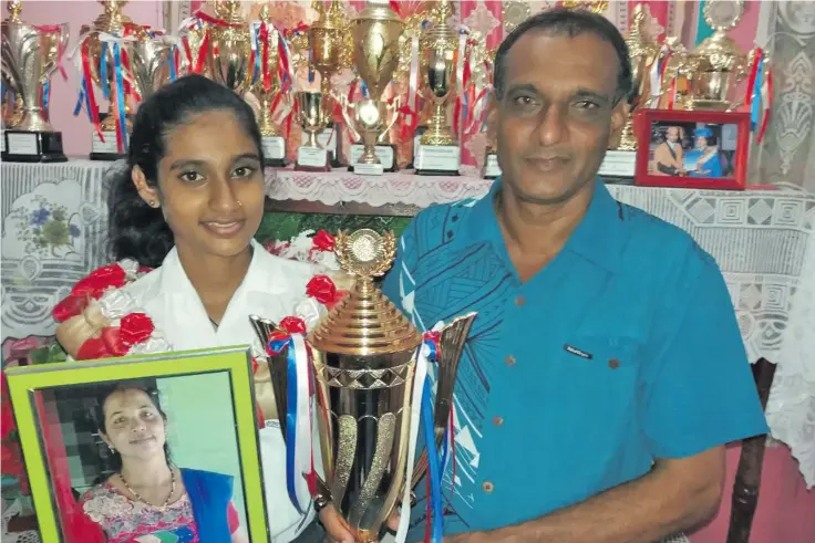  ??  ?? Deepshikha Priyashna (left) dux of Waiqele College in Labasa awarded with toppers scholarshi­p as she stood with her father, Ramesh Chand, with a picture of her late mother, Shaleeni Devi on January 14, 2019.