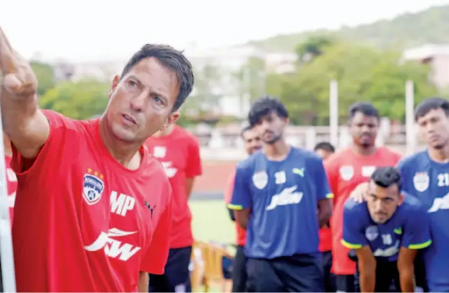  ?? Courtesy: Twitter ?? Bengaluru players listen to their coach during a training session on Wednesday.