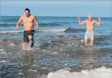  ?? | PHOTO PROVIDED BY KATIE MYSLIWIEC ?? Jimmy Gonzalez (left) of Munster and Mike Chinsky of St. Joseph, Mich., step into Lake Michigan on Thursday at Ogden Dunes.