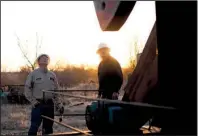  ?? The New York Times/BRANDON THIBODEAUX ?? Hubert Harris (left) with Tripledee Operating inspects one of the company’s pump jacks with contractor Marty Jones near Ardmore, Okla., earlier this month.