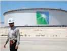  ?? — Reuters ?? An Aramco employee walks near an oil tank at Saudi Aramco’s Ras Tanura oil refinery and oil terminal in Saudi Arabia.