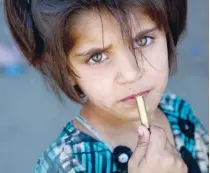  ?? — AFP ?? A Syrian girl, who fled Raqa, is seen with a bullet cartridge in her hand in the suburb of Jazra.