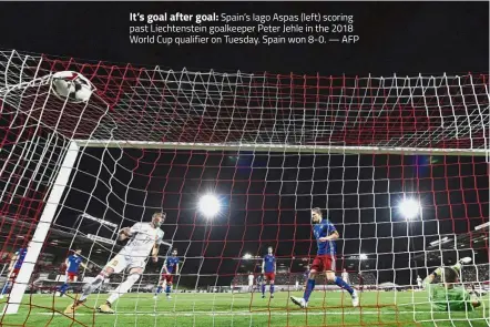  ?? — AFP ?? It’s goal after goal: Spain’s Iago Aspas (left) scoring past Liechtenst­ein goalkeeper Peter Jehle in the 2018 World Cup qualifier on Tuesday. Spain won 8- 0.