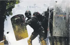  ??  ?? La Guardia Nacional se protege con sus escudos del arma reciente utilizada por la oposición: las “puputov”, frascos llenos de excremento.