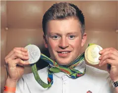  ?? PA/Getty. Pictures: ?? Above: Swimmer Adam Peaty, with his gold and silver medals, described sport as “a massively powerful thing”. Top: Team GB athletes arrive back at Heathrow.