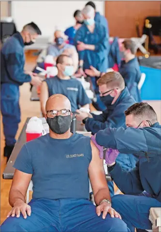  ?? SEAN D. ELLIOT/THE DAY ?? U.S. Coast Guard Capt. Arthur Ray, left, gets his first dose of the Pfizer BioNTech COVID-19 vaccine from Health Services Technician 3rd Class Justin Boulanger as personnel at the U.S. Coast Guard Academy are vaccinated Tuesday in the academy’s Leamy Hall.