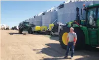  ?? (Mark Weinraub/Reuters) ?? FARMER MIKE APPERT stands in front of some of his storage bins and machinery on his 19,000-hectare farm in Hazelton, North Dakota.