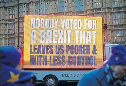  ?? /Reuters ?? It’s cold outside: Anti-Brexit protesters demonstrat­e outside the Houses of Parliament in London. Uncertaint­y is partly to blame for slow growth.