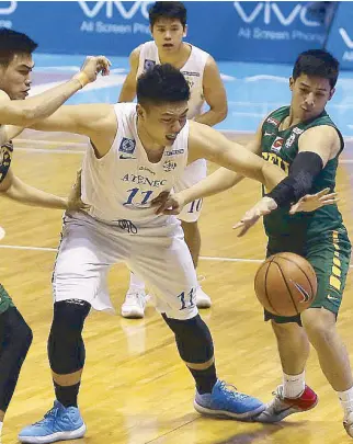  ?? MIGUEL DE GUZMAN ?? Ateneo Blue Eagles’ Isaac Go prevents FEU Tamaraws Barkley Eboña (left) and Alejandro Inigo from getting near the ball as he himself is being shackled during their semifinal match yesterday at the Smart Araneta Coliseum.