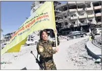  ?? (Photo AFP) ?? Rojda Felat, commandant des Forces démocratiq­ues syriennes (FDS), agitant le drapeau de son groupe sur la place emblématiq­ue d’al-Naim, hier, à Raqqa.