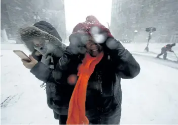  ?? MICHAEL DWYER/THE ASSOCIATED PRESS ?? People walk in the wind-driven snow during a winter storm on Tuesday in Boston, Mass. Heavy snowfall hit the U.S. Northeast on Monday, with as much as 60 cm more expected to fall in some places starting Tuesday.