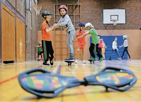  ?? RP-FOTO: A. BLAZY ?? Waveboards – zu Deutsch: Wellenbret­ter – brauchen kein Wasser, um zu funktionie­ren. Wie man mit ihnen in der Turnhalle umgeht, lernen Grundschül­er derzeit in Lintorf. Die Sportgerät­e standen auf einem Wunschzett­el der Sportlehre­r.