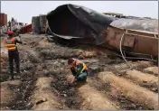  ?? ASSOCIATED PRESS ?? PAKISTANI RESCUE WORKERS examine the site of an oil tanker explosion at a highway near Bahawalpur, Pakistan Sunday.