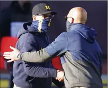  ?? CARLOS OSORIO — THE ASSOCIATED PRESS ?? Michigan head coach Jim Harbaugh, left, greets Penn State head coach James Franklin after Saturday’s game in Ann Arbor. Penn State won 27-17.