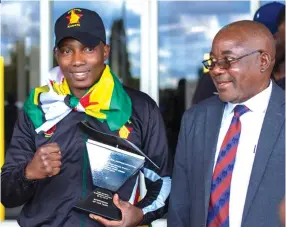  ??  ?? KODAK . . . Kobudo champion Wilfred Mashaya (left) poses for a picture with his father MOMENT Jameson Mashaya, at the Robert Gabriel Mugabe Internatio­nal Airport, upon his return from Namibia where he was crowned Regional Sportsman of the year Award back in 2019