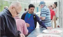  ?? LUKE EDWARDS METROLAND ?? Visitors to Vineland Research and Innovation Centre test a greenhouse tomato during tours of the facility’s greenhouse tomato program.