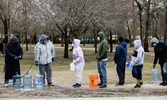  ?? Photograph: Brett Coomer/AP ?? People line up to fill containers of various sizes from a spigot at Haden Park Thursday in Houston, Texas.