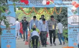  ?? HT PHOTO ?? A woman being wheeled into a model polling booth in Karnal and (right) interiors of a booth in the segment gave the look of a wedding venue.