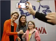  ?? PATRICK SEMANSKY — THE ASSOCIATED PRESS ?? Presidenti­al candidate Sen. Elizabeth Warren, D-Mass., left, poses for a photo with attendees after speaking at a campaign event Sunday in Marshallto­wn, Iowa.