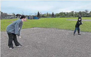  ?? THE CANADIAN PRESS ?? Siblings Ella Pringle and Aidan Ridley play a game of baseball as a part of their parents’ “conscious” effort to get them more active outside.