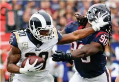  ?? Associated Press ?? Los Angeles Rams running back Todd Gurley pushes away Houston Texans outside linebacker Jadeveon Clowney during the first half of an NFL football game Sunday in Los Angeles.