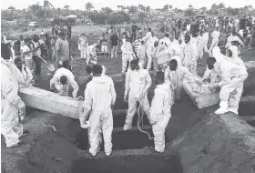  ??  ?? In this Thursday, August 17 file photo, volunteers handle a coffin during a mass funeral for victims of heavy flooding and mudslides in Regent at a cemetery in Freetown, Sierra Leone. Churches across Sierra Leone held special services yesterday in...