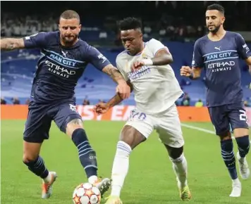  ?? ?? Stop me if you can.... Real Madrid's Vinicius Junior seems to tell two defenders of Man City when they met at the Bernabeu in the semifinal of the UEFA Champions League on May 8, 2023. They will meet in the quarterfin­al this time.