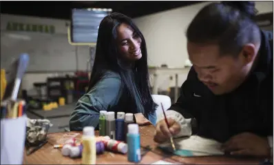  ?? (NWA Democrat-Gazette/Charlie Kaijo) ?? Marshalles­e artist Joyce Hitchfield works with Raygon Jacklick, 17, of Springdale on an art project earlier this month at The Station in Springdale.