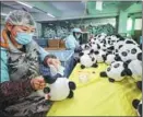  ?? PHOTOS BY DONG YANJUN AND LI HONGTU / FOR CHINA DAILY ?? From top: In the production workshop of Jinjiang Hengsheng Toys in Jinjiang, Fujian province, workers sew Bing Dwen Dwen; Workers fill the sewn plush panda dolls with cotton; In a factory in Dehua, Fujian, workers apply decals to the ceramic version of Bing Dwen Dwen; Workers check if the cotton is filled with the desired amount.