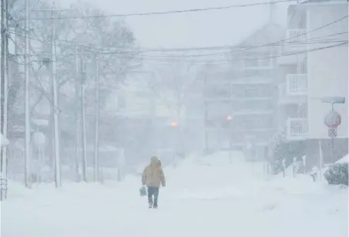  ?? STEPHEN MACGILLIVR­AY LA PRESSE CANADIENNE ?? À Moncton, au Nouveau-Brunswick, un piéton marche au centre d’une rue désertée par les automobili­stes au début de la tempête.