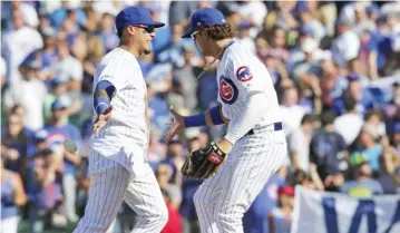  ?? GETTY IMAGES ?? Shortstop Javy Baez and center fielder Albert Almora celebrate the Cubs’ victory Friday against the Brewers.