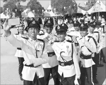  ??  ?? Newly-graduated constables take a group selfie to commemorat­e the end of their training.