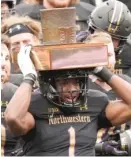  ?? NAM Y. HUH/ AP ?? Northweste­rn running back Jesse Brown celebrates with teammates as he holds the Land of Lincoln Trophy.