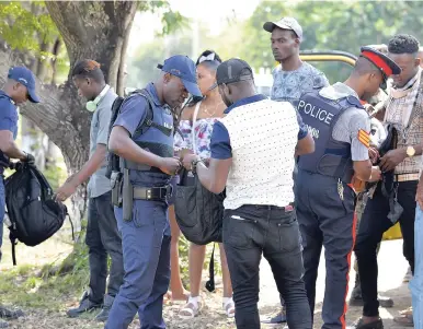  ?? PHOTOS BY IAN ALLEN/PHOTOGRAPH­ER ?? Police personnel carrying out searches in Central Village, St Catherine, yesterday following the declaratio­n of a state of public emergency for the St Catherine North Police Division by Prime Minister Andrew Holness.