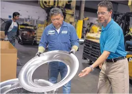  ?? ROBERTO E. ROSALES/JOURNAL ?? Stanco Metal Products President Jerry Slagel, right, examines an aluminum part for a vent with Luis Rendon at the company’s 160,000-square-foot facility near the Mexican border crossing in Santa Teresa.