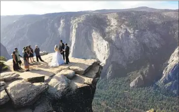  ?? Amanda Lee Myers Associated Press ?? A COUPLE exchange wedding vows atop Taft Point in California's Yosemite National Park last month.