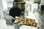  ?? ?? An employee removes “Crookies” from an oven, a traditiona­l French croissant mixed with cookie dough, in the pastry shop of French pastry chef Stephane Louvard in Paris.