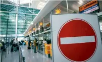  ?? — Reuters ?? Passengers wait in front of a check-in desk during a pilots’ strike by Lufthansa at Munich airport.