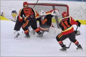  ?? SAM STEWART — DIGITAL FIRST MEDIA ?? Downingtow­n East’s Justin Cohn is checked in front of West Chester East goalie Joseph Galitsky during Thursday’s Ches-Mont League final at Ice Line.