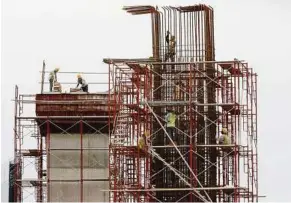  ??  ?? Workers prepare scaffoldin­gs to pour concrete into a giant column for the 150-km Mass Rapid Transit system in Kuala Lumpur. — AP