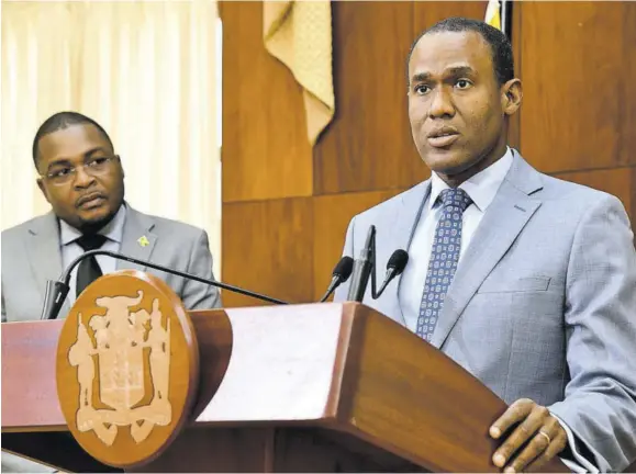  ?? (Photo: JIS) ?? Minister of Finance and the Public Service Dr Nigel Clarke addressing Wednesday’s post-cabinet press briefing at Jamaica House. At left is minister without portfolio with responsibi­lity for informatio­n in the Office of the Prime Minister, Robert Morgan.